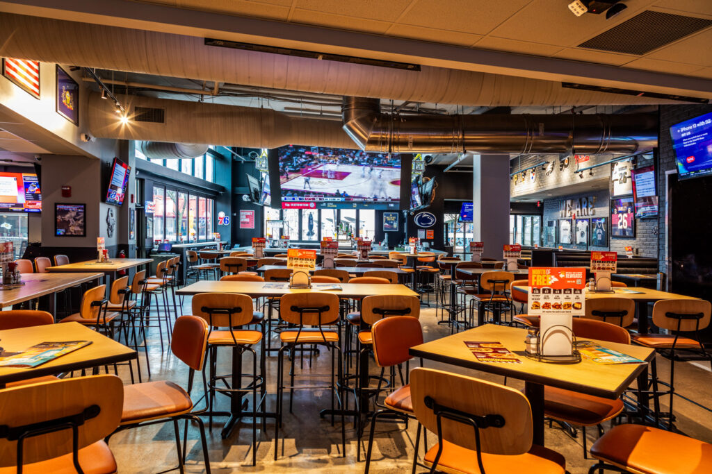 Interior shot showcasing the double-height bar area with multiple flat-screen TVs and contemporary lighting.
